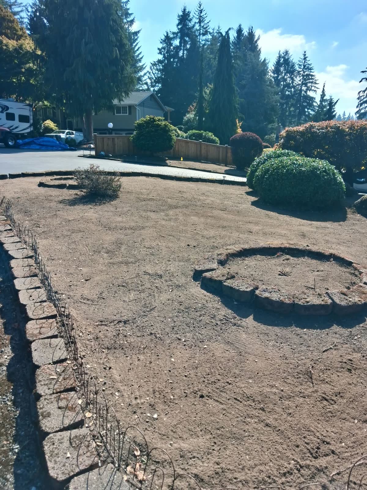 Before: the front yard as dry bare dirt around a stone circle bed.