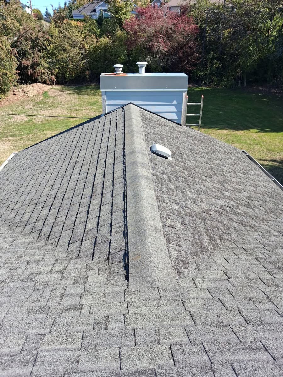 A clean hip roof with a chimney cap, after cleaning.