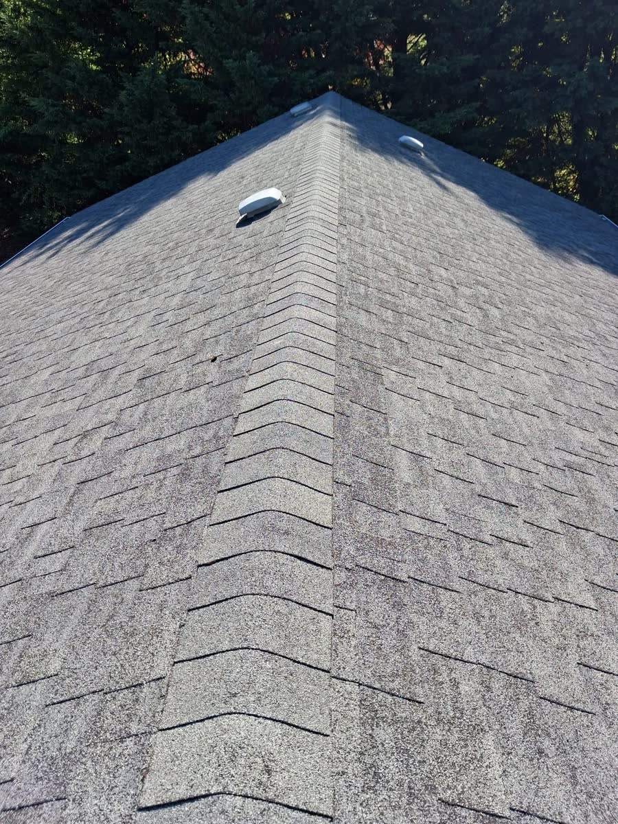 A clean grey shingle roof and ridge after cleaning.